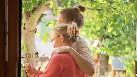 Eine jüngere Frau umarmt eine ältere Frau: Neuanfang mit 60: Heike Ehmann aus Lorch-Waldhausen (Ostalbkreis) ist jetzt Erzieherin. Sie arbeitet mit ihrer Tochter Pauline Geiger im evangelischen Kindergarten zusammen.