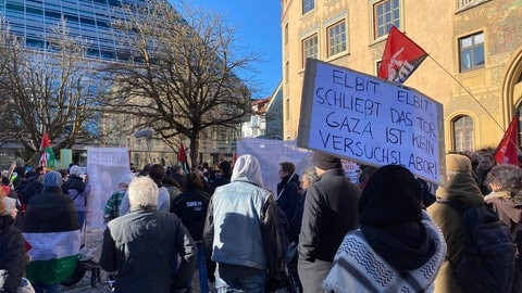 Fahnen und Plakate auf dem Marktplatz in Ulm - rund 150 Menschen versammelten sich dort bei einer Demo gegen ein israelisches Rüstungsunternehmen. 