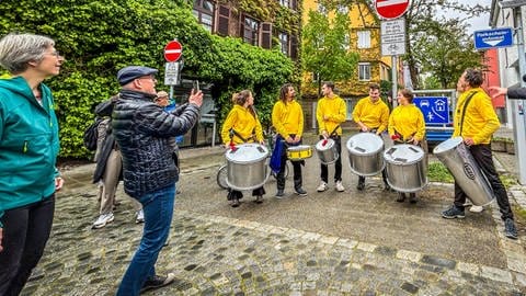 Verkehrsminister Winfried Hermann fotografiert die in Ulm eingerichtete Schulstraße, die zu Stoßzeiten für Autos gesperrt ist. Solche Schulstraßen sind ein Teil von modernen Fußverkehrskonzepten. Verkehrsminister Winfried Hermann ist begeistert von der Umsetzung der Schulstraße in der Ulmer Glasgasse. Er möchte mehr Kommunen dazu anregen, Schulstraßen einzurichten, um das Verkehrschaos vor den Bildungseinrichtungen aufzulösen.  