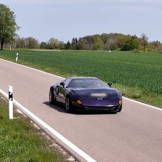 Schwarz statt Orange: Auf einer Landstraße ist der Nachbau des Sportwagens Mercedes C111 unterwegs.