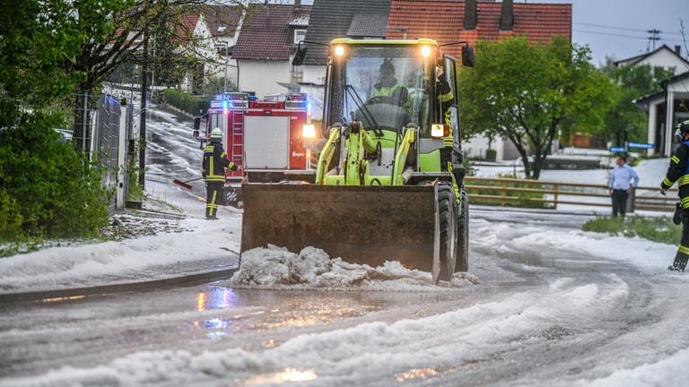 In Söhnstetten (Kreis Heidenheim) musste die Feuerwehr mit einem Radlader die Straße vom Hagel befreien (16. Mai).