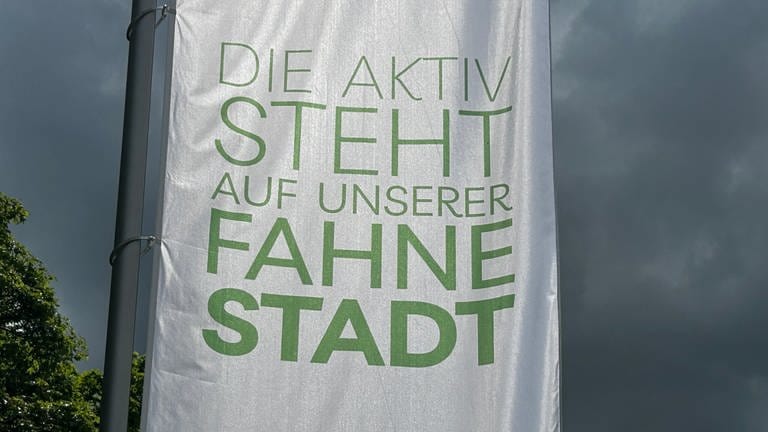 Eine Fahne am Schlossberg in Heidenheim mit der Aufschrift "Die aktiv steht auf unserer Fahne Stadt".Die Fahnen am Schlossberg in Heidenheim sind Teil der neuen Marketingkampagne. Der Slogan sorgt bei vielen für Verwirrung.
