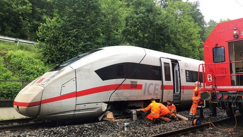 Bahnmitarbeitende versuchen, den verunfallten Zug mit einer Spezialhydraulik wieder aufs Gleis zu heben