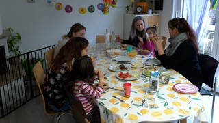 Mütter beim Mittagessen in der Wohngemeinschaft. Das gemeinsame Mittagessen gehört zum Leben in der Mütter-WG dazu. Mit dabei auch die Betreuerinnen der Lebenshilfe.