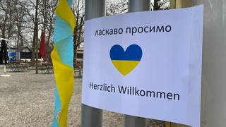 Ein Zettel mit einem blau-gelben Herzen und Herzlich Willkommen: für Flüchtlinge aus der Ukraine in Ulm
