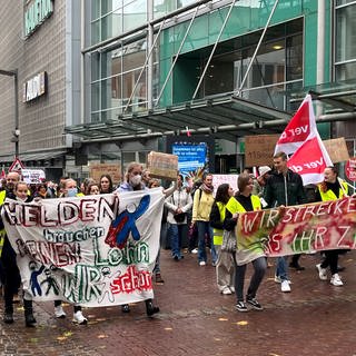 Bei einem Demonstrationszug durch die Ulmer Innenstadt bekräftigten Beschäftigte der Uniklinik mit Trillerpfeifen und Transparenten ihre Forderungen.