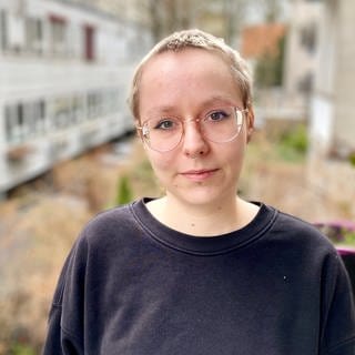 Helene Schüle steht auf ihrem Balkon. Die Post Covid-Patientin kann sich aufgrund ihrer Symptome nur bedingt körperlich belasten. Sie leidet noch unter Atemlosigkeit und Erschöpfung. 