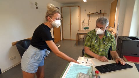 Arzthelferin bringt Kinderarzt Klaus Rodens das Impfbesteck, er impft täglich gegen Masern, nicht erst seit der Impfpflicht.