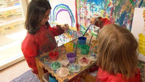 Kinder spielen in einer Einrichtung mit Farben. 
