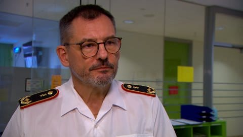 Ein Mann in weißer Uniform mit ärztlichem Generalabzeichen