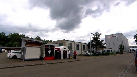 Ein Imbisswagen mit angebautem Zelt an einer Straße: Eher unscheinbar, die Wurstbraterei Hafner mitten im Gewerbegebiet. Jeden Mittag gibt es hier eine Schlange. 