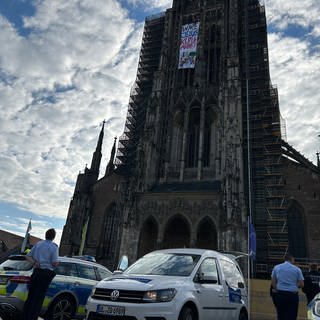 Ein Banner hängt am Turm des Ulmer Münsters.