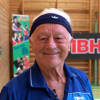 Hans Ohlhauser lächelt in die Kamera. Auf der Stirn sein Markenzeichen: Das Stirnband. Er tritt bei der Senioren WM im Tischtennis in Rom an.