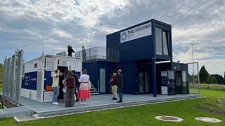 In mehreren Containern am Energiepark der Technischen Hochschule Ulm befinden sich ein Batteriespeicher, eine Elektrolyseanlage zur Herstellung von Wasserstoff und eine Gasturbine. Der Energiepark an der Technischen Hochschule Ulm. Hier wird untersucht, wie verschiedene nachhaltige Energiesysteme, wie Sonnenenergie oder Wasserstoff, zusammenarbeiten können.