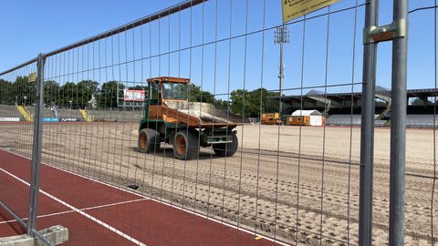 Ein Bagger bereitet den Platz im Donaustadion in Ulm für den Rollrasen vor, der Ende der Woche geliefert werden soll.
