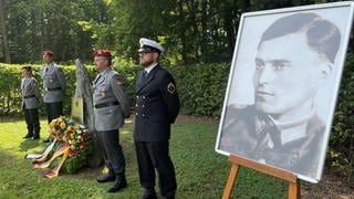 Ein großes schwarz-weiß Porträt von Stauffenberg ist bei der Gedenkfeier in der Wilhelmsburg-Kaserne in Ulm aufgestellt. 
