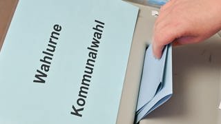 Ein Wahlbrief wird in die Wahlurne der Kommunalwahl eingeworfen, in Bleubeuren-Pappelau muss die Wahl für den Ortschaftsrat wiederholt werden. 