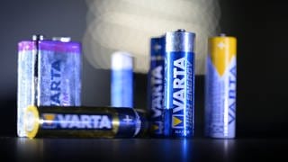 Mehrere Batterien des Herstellers Varta werden von einer Taschenlampe angestrahlt. 