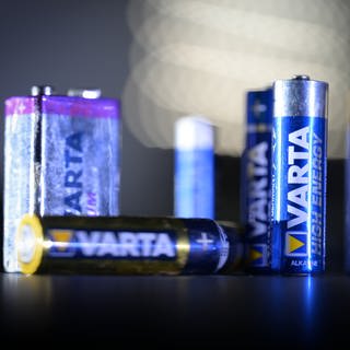 Mehrere Batterien des Herstellers Varta werden von einer Taschenlampe angestrahlt. 