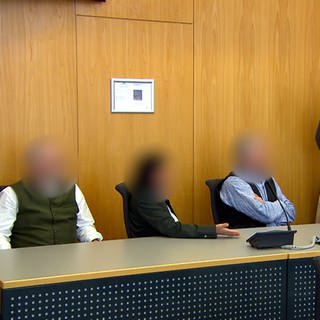 Die drei Adoptivkinder Erwin Müllers mit ihrem Anwalt vor Gericht - sie klagen um den Pflichtteil ihres Erbes.