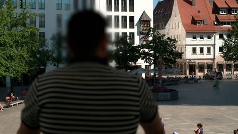 R. Öezcelik blickt auf den Münsterplatz. Er ist nur von hinten zu erkennen. Der Ladendetektiv aus Ulm gibt auch Schulungen, um Ladeninhaber und Personal für das Thema Ladendiebstahl zu sensibilisieren.