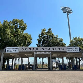 Der Haupteingang zum Ulmer Donaustadion. Im Hintergrund ein Flutlicht. Am Freitagabend steigt hier das Pokalspiel SSV Ulm 1846 Fußball gegen Bayern München.