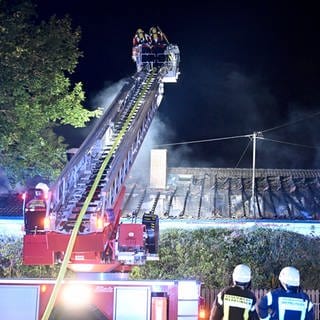 Feuerwehrleute löschen von einer Drehleiter aus ein Feuer im Dachstuhl. Der Brand zerstört das Einfamilienhaus in Merklingen. Die Familie, die darin wohnte, war nicht zuhause. 