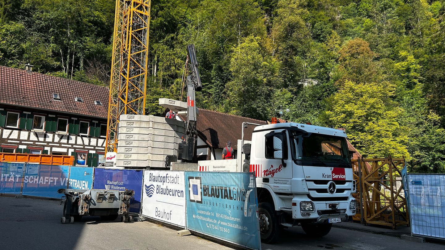 Eine Baustelle mit Baufahrzeugen: Der Blautopf ist zurzeit nicht sichtbar, Die Baustelle am Blautopf in Blaubeuren wird die nächsten vier Jahre den Besucherverkehr einschränken - die Gastronomen in der Stadt sind besorgt.