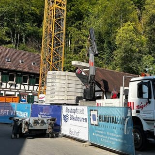 Eine Baustelle mit Baufahrzeugen: Der Blautopf ist zurzeit nicht sichtbar, Die Baustelle am Blautopf in Blaubeuren wird die nächsten vier Jahre den Besucherverkehr einschränken - die Gastronomen in der Stadt sind besorgt.