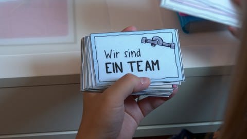 "Wir sind ein Team" steht auf einer Motivationskarte, die Victoria Kaiser für ihre Schülerinnen und Schüler vorbereitet hat. Sie ist künftig Lehrkraft an der Elly-Heuss-Realschule in Ulm und war am Freitag bei der Vereidigung dabei.