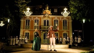 Robin Kucher steht verkleidet mit weiteren Darstellen vor dem Rokokoschlösschen in Schwäbisch Gmünd. Sein Stück "Rendevouz durch die Zeit" ist eine Kombination aus Musical, Theater und Stadtführung in Schwäbisch Gmünd. 