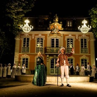 Robin Kucher steht verkleidet mit weiteren Darstellen vor dem Rokokoschlösschen in Schwäbisch Gmünd. Sein Stück "Rendevouz durch die Zeit" ist eine Kombination aus Musical, Theater und Stadtführung in Schwäbisch Gmünd. 