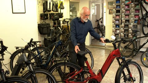 Klaus Grässle schiebt eines seiner E-Bikes aus seinem Laden in Schwäbisch Gmünd. Mittlerweile verkauft er fast nur noch Räder mit elektrischer Unterstützung.