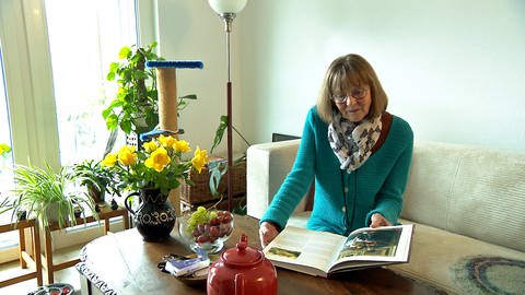 Eine Seniorin sitzt mit ihrem Tee und einem Buch in einem gemütlichen Wohnzimmer. Alt und Jung zusammen in einem Quartier - und die entsprechende Infrastruktur, das ist die Idee des Wohnprojekts in Schwäbisch Gmünd.