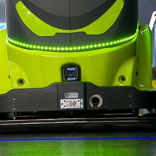 Grüner Putzroboter der Firma Adlatus in Großaufnahme mit Sensoren und LED-Lichtern kommuniziert visuell und akustisch mit Menschen in Ulm