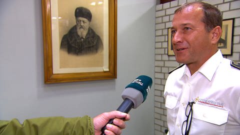 Reiner Buschow, stellvertretender Kommandant der Ulmer Feuerwehr steht vor einem Bild von Conrad Dietrich Magirus. Nun wurde der 200. Geburtstag von Magirus gefeiert.