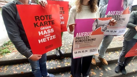 Aktivisten mit Plakaten auf einer Treppe - sie organisieren den Protest gegen ein Treffen der AfD. Sie will in der Ulm Messe im Oktober und November ihren Landesparteitag abhalten.