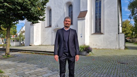 Pfarrer Ralf Sedlak vor seiner Kirche in Langenau in Alb-Donau-Kreis. Seit er in einer Predigt den Angriff der Hamas auf Israel erwähnt hat, wird er bedrängt und angepöbelt.