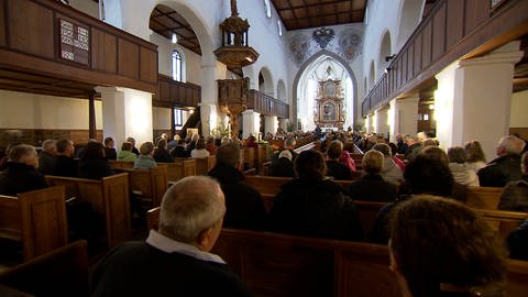 Die Martinskirche in Langenau von innen. Viele der Bänke sind voll besetzt. Vor der Kirche gibt es seit Monaten Psychoterror, nachdem Pfarrer Ralf Sedlak in einer Predigt den Angriff auf Israel erwähnt hat. 