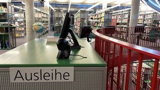 Ausleihe am Eingang der Stadtbücherei Ulm, Bücherregale im Hintergrund: Bibliotheken von Ulm bis Aalen ringen mit dem Umgang mit umstrittener Literatur.