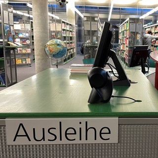 Ausleihe am Eingang der Stadtbücherei Ulm, Bücherregale im Hintergrund: Bibliotheken von Ulm bis Aalen ringen mit dem Umgang mit umstrittener Literatur.