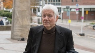 Anton Schlecker, weißhaarig, in schwarz gekleidet 2017 auf dem Weg zum Landgericht Stuttgart. Das Gericht verurteilte den früheren Drogerieköng wegen vorsätzlichen Bankrotts zu zwei Jahren auf Bewährung und einer Geldstrafe von 54.000 Euro. Seit dem Urteil ist Anton Schlecker nicht mehr in der Öffentlichkeit aufgetreten. 