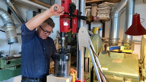 Mit dem Bohrer holt Holzkünstler Martin Mayer das Kernstück aus dem Holzblock, aus dem die Urne entsteht. Aus dem Kernstück fertigt er dann ein Kunstwerk, als Erinnerung für die Hinterbliebenen.