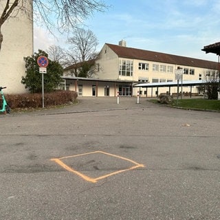 Vor der Schule ist ein orangenes Quadrat aufgemalt. Hier soll ein ehemaliger Schüler der Sägefeld-Schule in Ulm-Wiblingen einen Lehrer niedergeschlagen und lebensbedrohlich verletzt haben. 