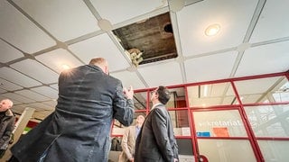 Zwei Männer betrachten eine undichte Stelle in der Decke. Das Schulzentrum in Ulm-Wiblingen soll Jahren saniert werden. 