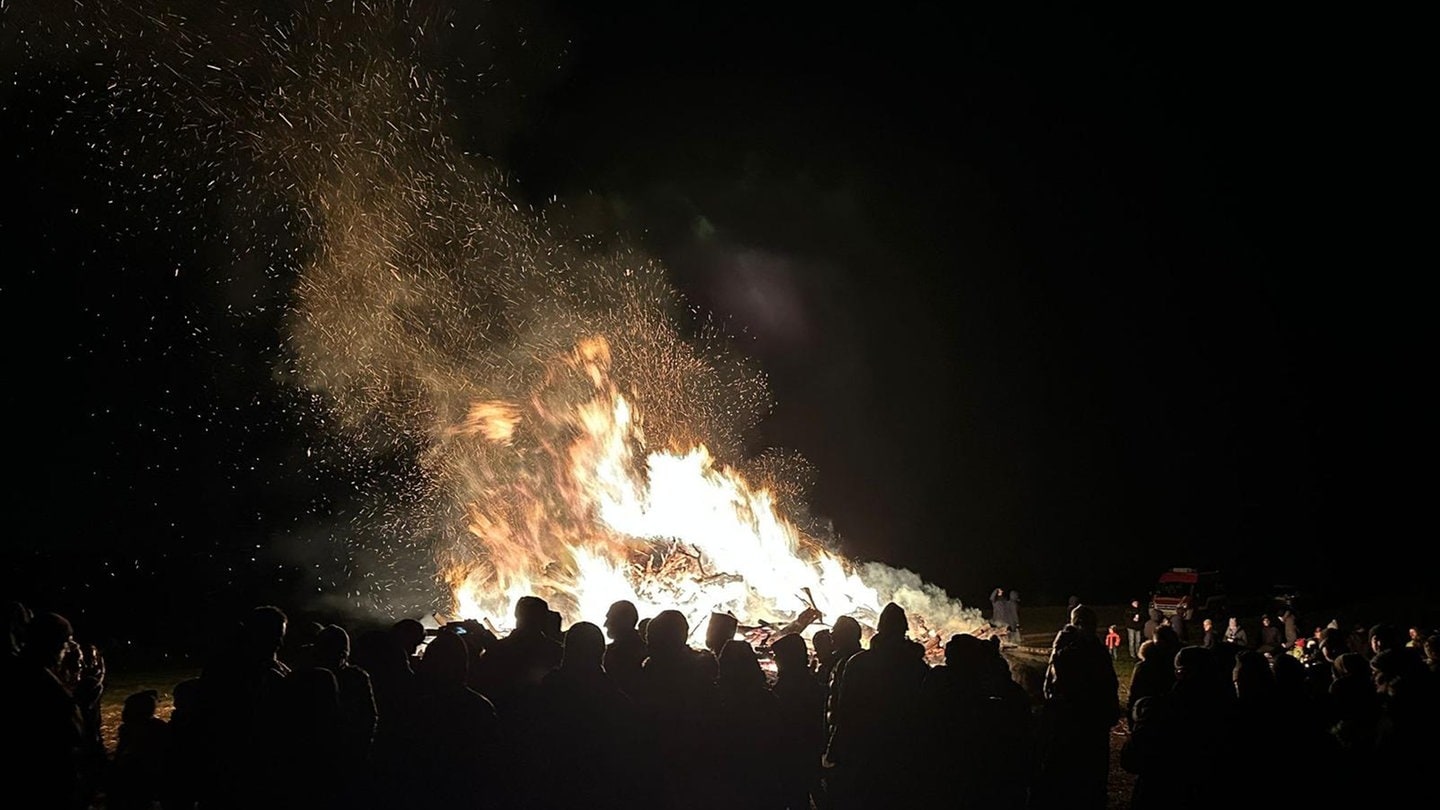 Flammen eines Funkenfeuers lodern in den Nachthimmel, davor eine Zuschauermenge. Das Funkenfeuer in Dietenheim-Regglisweiler (Alb-Donau-Kreis) war das bislang größte der Ortsgeschichte.