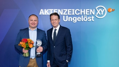 Andreas Bichert aus Langenau und Moderator Rudi Cerne nach der Verleihung des XY-Preises. Andreas Bichert hatte in Langenau (Alb-Donau-Kreis) ein Neugeborenes aus einem Glascontainer gerettet, er wurde am Montagabend ausgezeichnet.