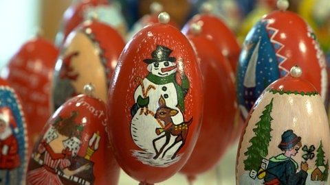 Dieses Gänseei gleicht fast einer Christbaumkugel. Auf roter Grundierung ist ein Schneemann mit einem Rehkitz zu sehen. Für den Osterbrunnen in Schechingen wird auch zur Weihnachtszeit gearbeitet.