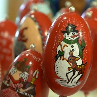 Dieses Gänseei gleicht fast einer Christbaumkugel. Auf roter Grundierung ist ein Schneemann mit einem Rehkitz zu sehen. Für den Osterbrunnen in Schechingen wird auch zur Weihnachtszeit gearbeitet.