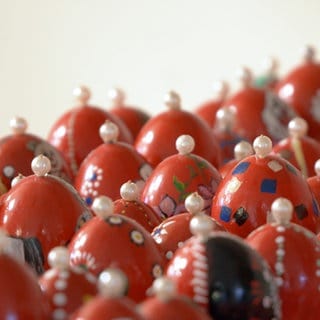 Viele rote Ostereier stecken einzeln auf Schachlickspießen eng aneinander im Rathaus. Sie sind oben mit Perlen versehen. Gerade zur Weihnachtszeit könnten sie beinahe mit Christbaumkugeln verwechselt werden.